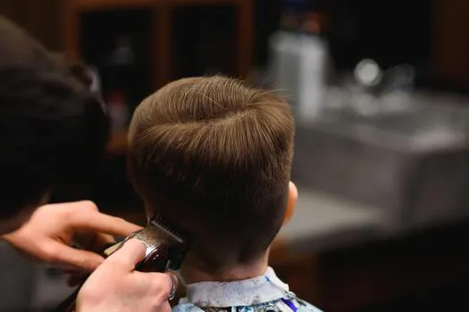 a-little-cute-boy-sits-in-a-hairdresser-s-at-the-stylist-s-a-schoolchild-is-getting-hair-cut-in-a-beauty-salon-a-child-at-a-barbershop-s-a-short-men-s-haircut-photo